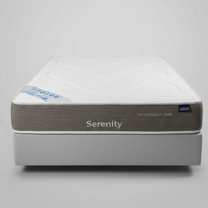 Bed with a mattress in a room with decorative wall tiles , the brand name is Auconfort , the main name of this mattress is Serenity.